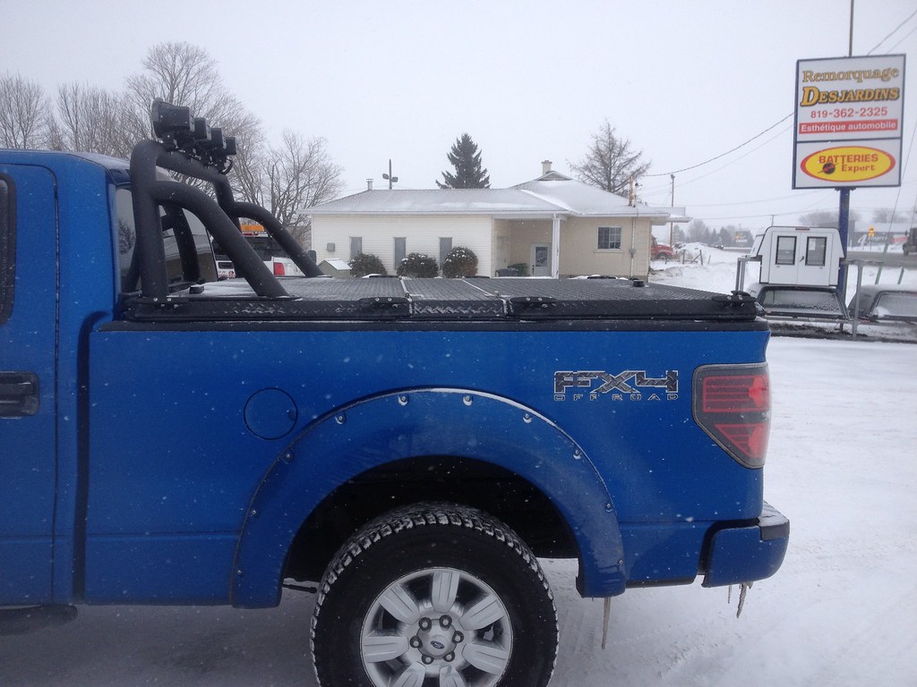 A hard tonneau cover installed on a pickup truck bed, providing a flat locking surface over the cargo area