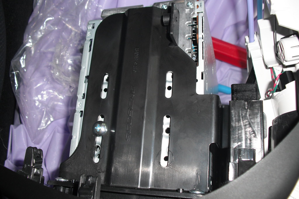 Hands aligning an aftermarket double-DIN head unit into a vehicle dash opening during installation
