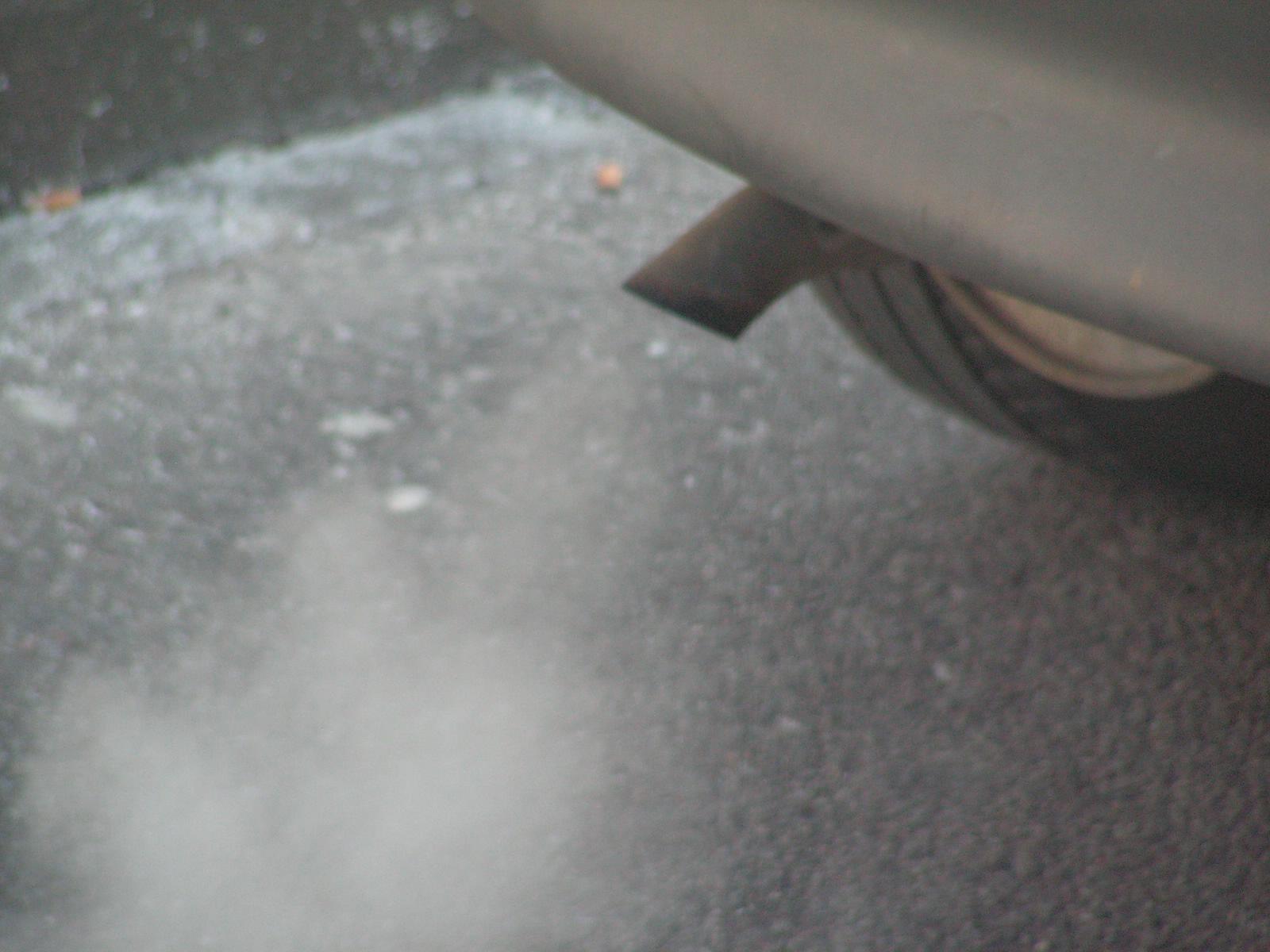 Close-up of visible exhaust vapor from a vehicle tailpipe.