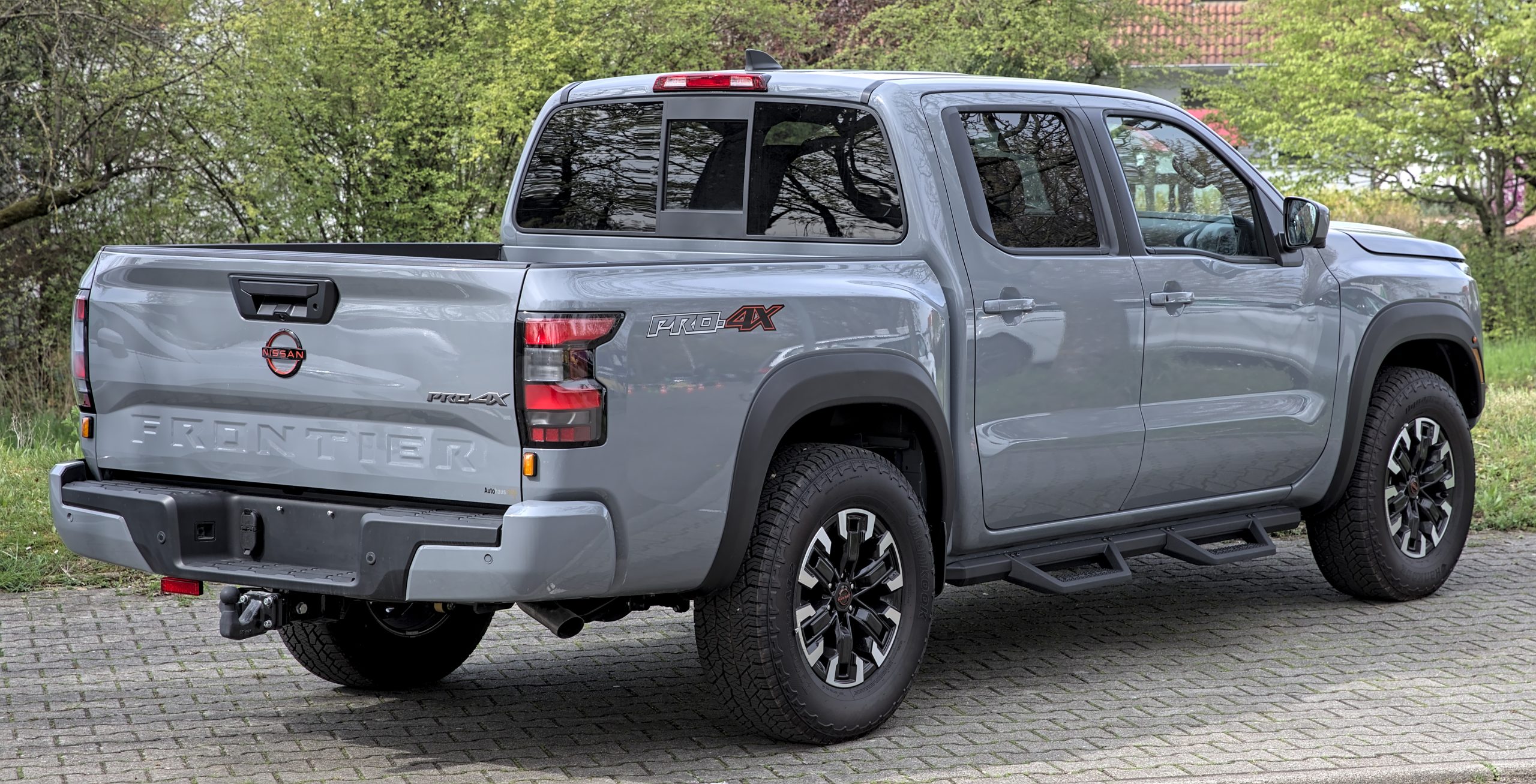 A silver Nissan Frontier D41 Pro-4X pickup truck showing its factory LED headlight and front grille design.