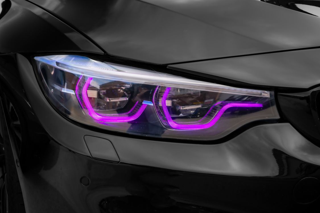 Close-up of a modern LED car headlight with illuminated ring detail.