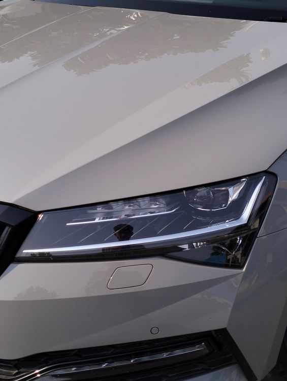 Close-up of a modern vehicle headlight housing and chrome reflector detail.