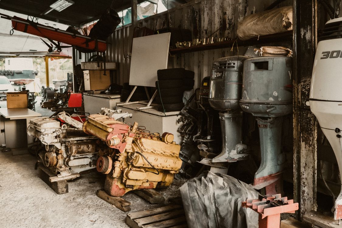 Multiple outboard motors stored in a marine repair workshop.