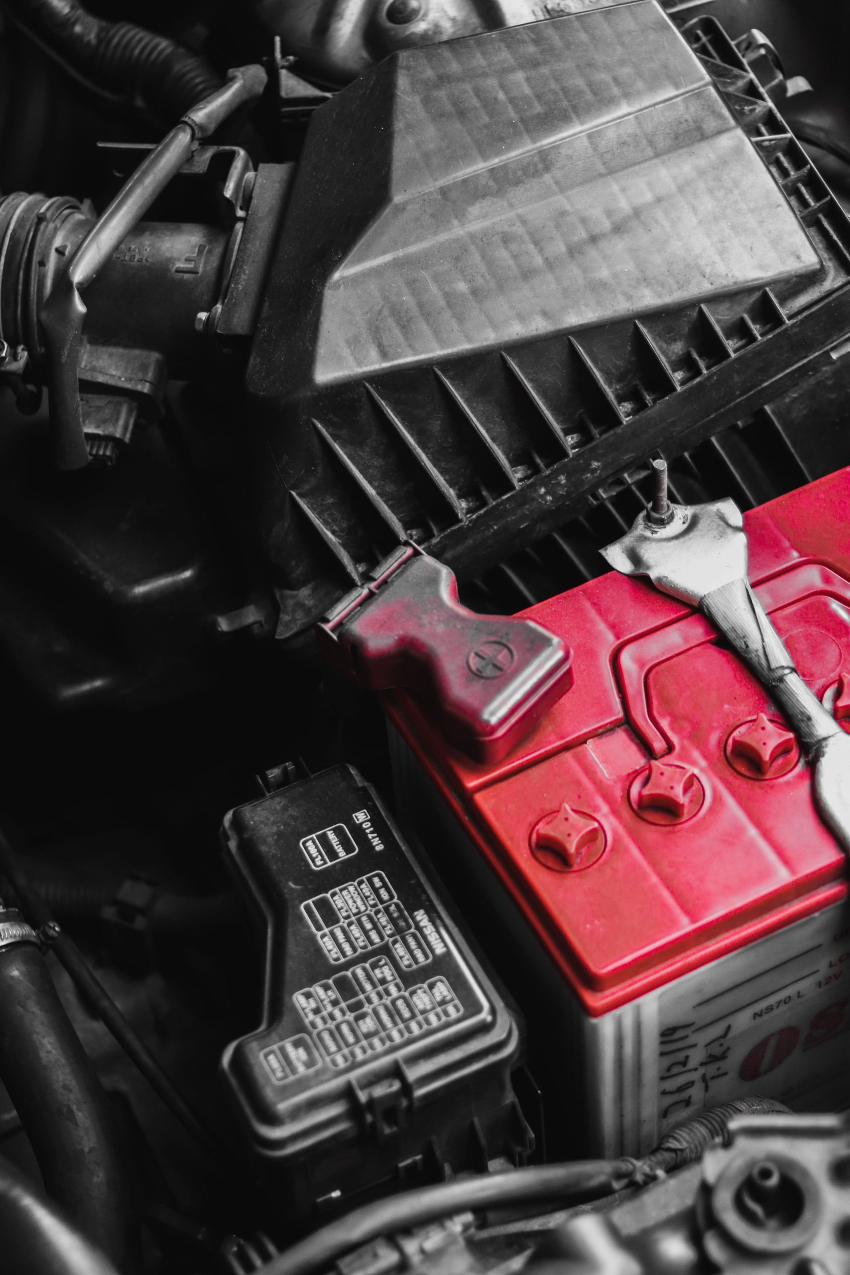 Close-up of a car battery terminal with cables attached, ready for a power inverter connection.